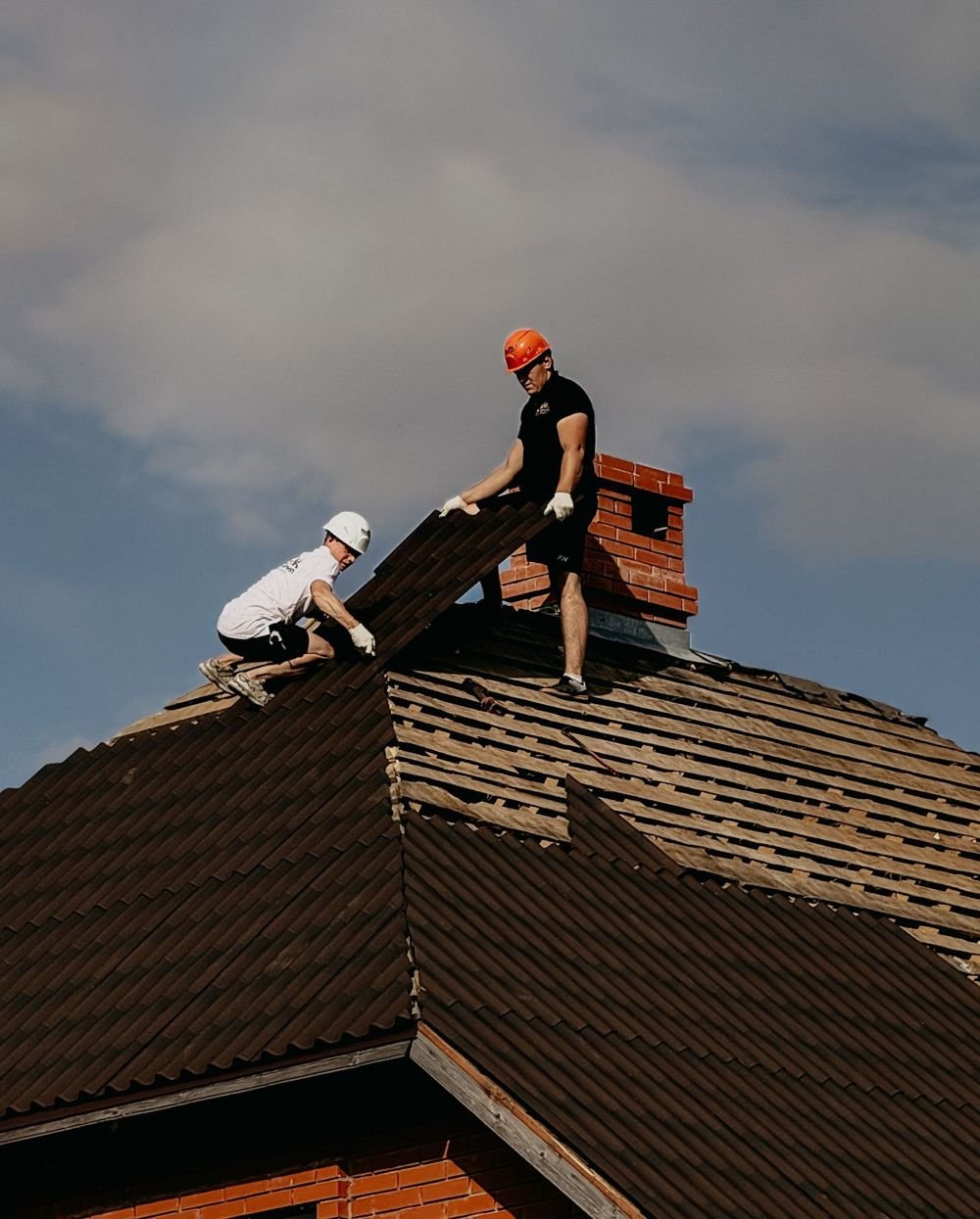 Roofing workers repairing a residential roof